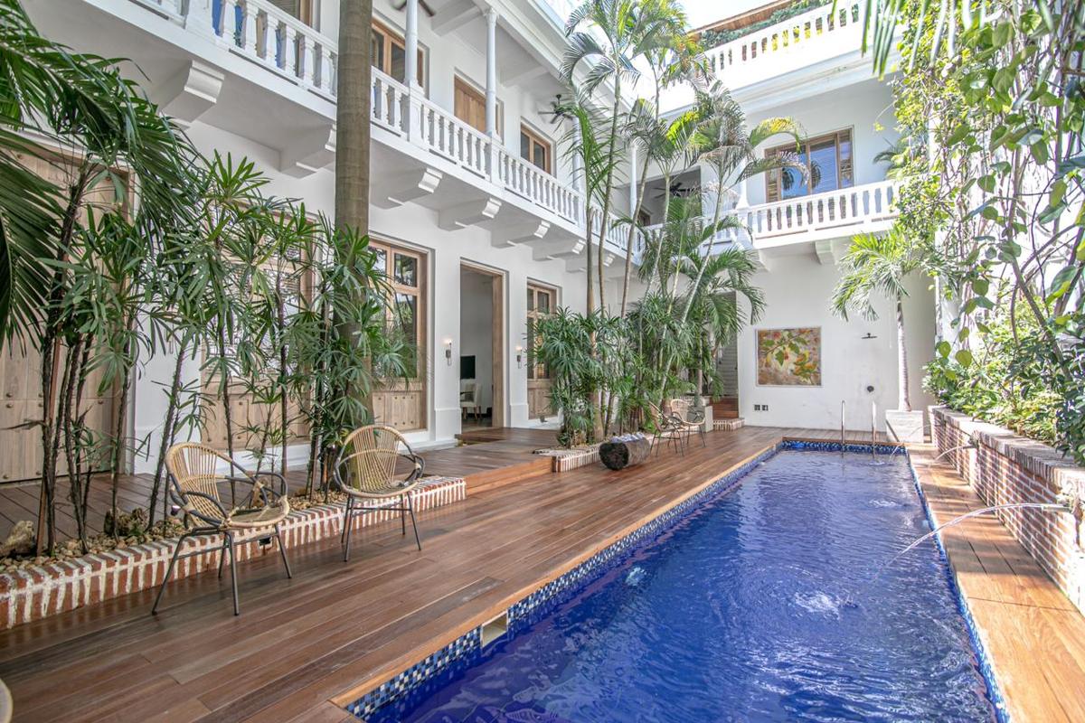 El patio de Casa Belle con su piscina larga entre palmas