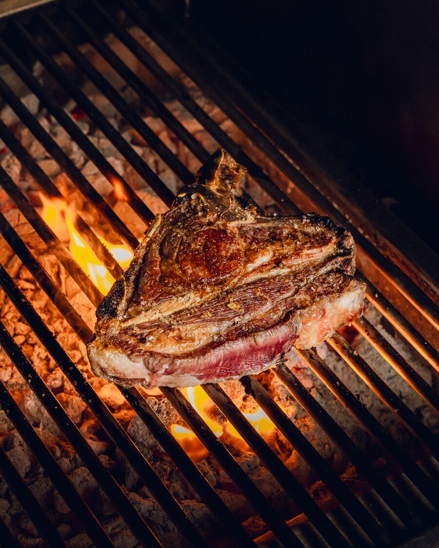 Tomahawk sellándose sobre la parrilla con llamas