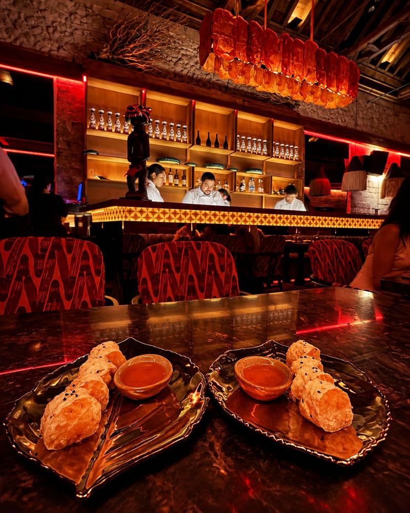 Barra de sushi de SLVJ en rojo y ámbar, con hosomaki en primer plano