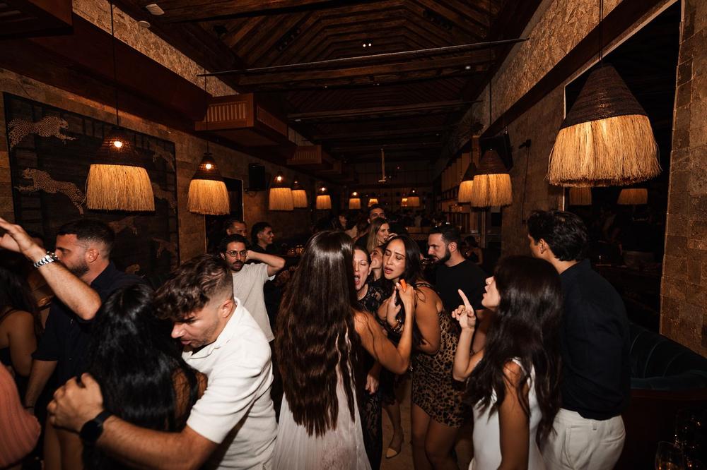 Gente bailando en SLVJ bajo las lámparas de fibra