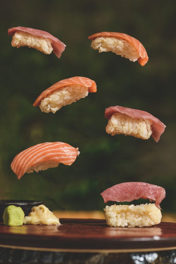 Nigiris de salmón, atún y hamachi en el aire